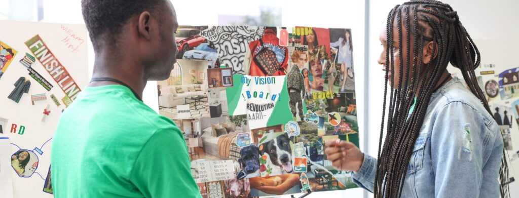 Two students look at a vision board together